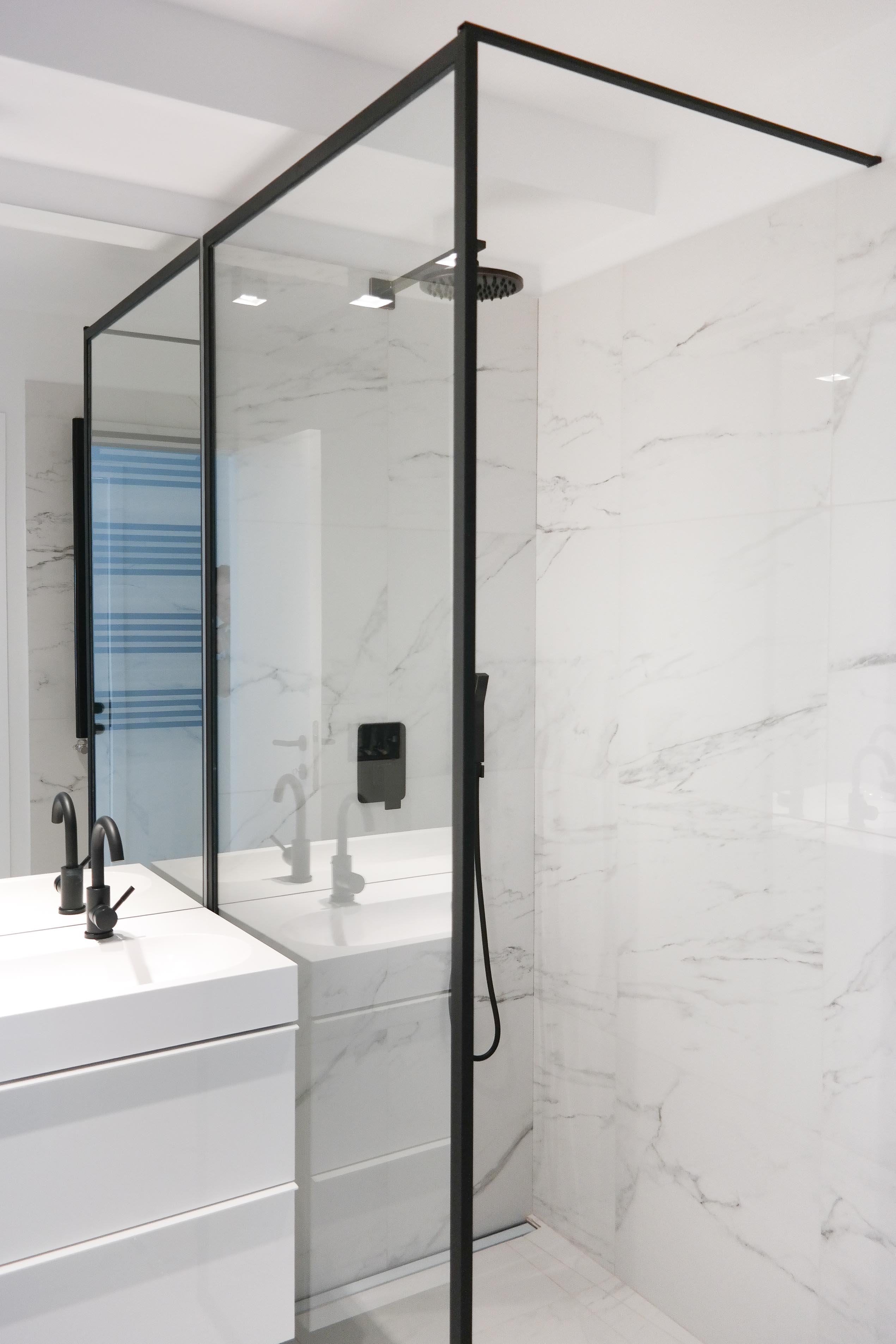 Moderne badkamer met inloopdouche, marmerlook tegels en zwart kraanwerk